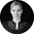 Alissa S. Mitglied der Online Marketing Community, fotografiert vor schwarzem Hintergrund mit detaillierter Bluse.
