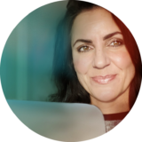 Online-Marketing-Team mit lächelnder Frau, die am Laptop arbeitet.