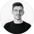 Niklas Wotschel, webgefährte, präsentiert sich mit Brille und kurzem Bart in einem lässigen schwarzen T-Shirt.