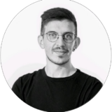 Niklas Wotschel, webgefährte, präsentiert sich mit Brille und kurzem Bart in einem lässigen schwarzen T-Shirt.